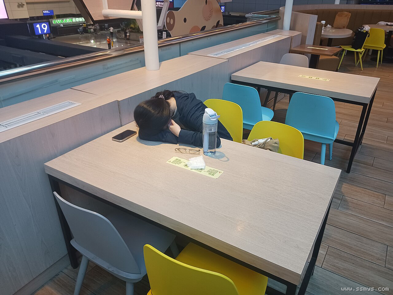 大睡理论示意图:一名旅客在机场座椅上睡觉